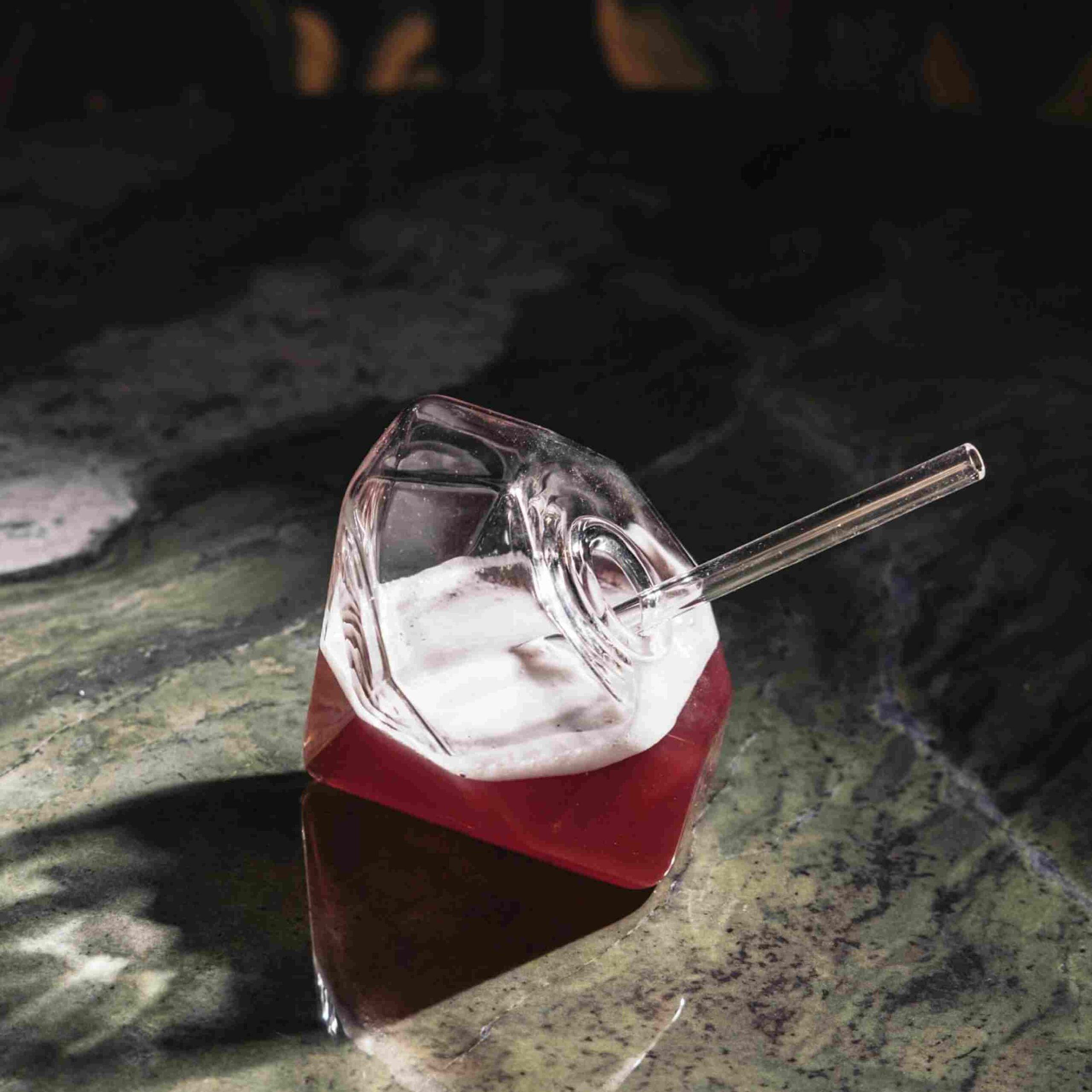 Ruby red cocktail in diamond-shaped glass at cocktail bar in St. Julian’s, Malta