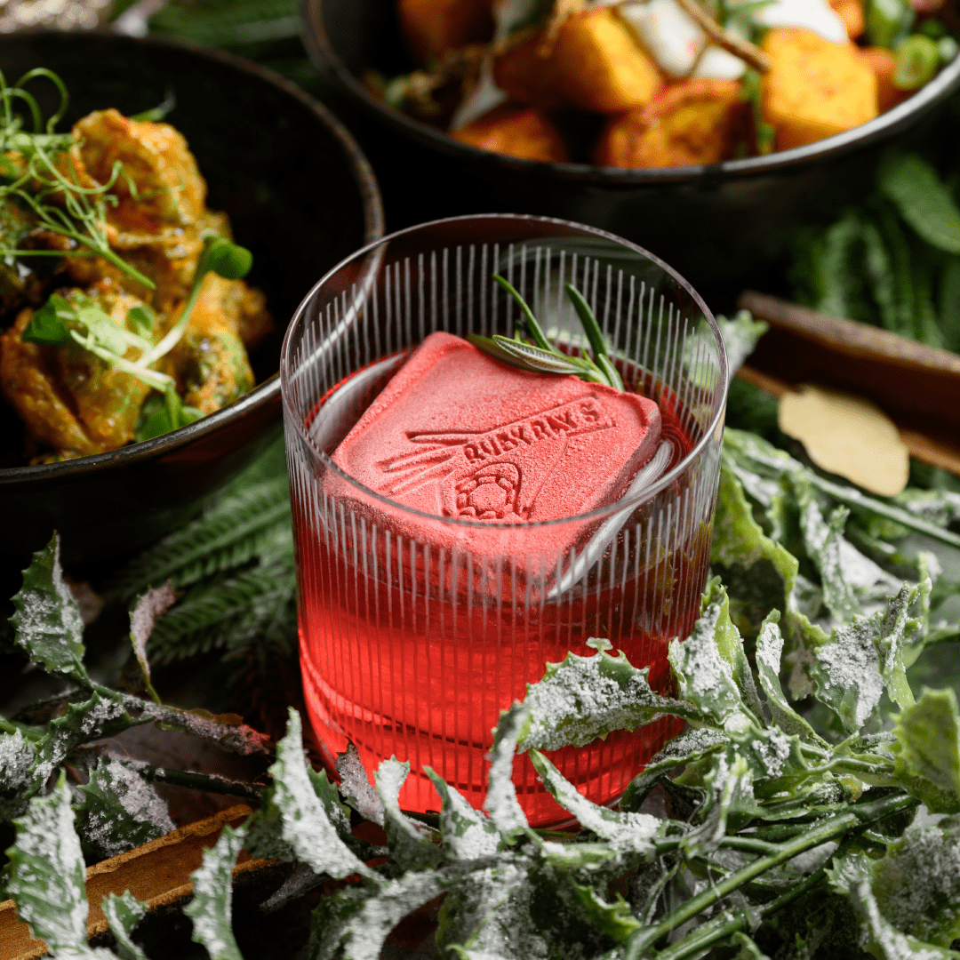 Festive cocktail served at Ruby Rays Malta with glowing bar lights and vibrant seasonal decorations.